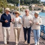 Groupe de quatre seniors souriants sur la Promenade des Anglais