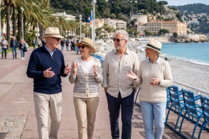 Groupe de quatre seniors souriants sur la Promenade des Anglais
